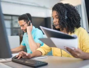 homme et femme devant ordinateur avec casque